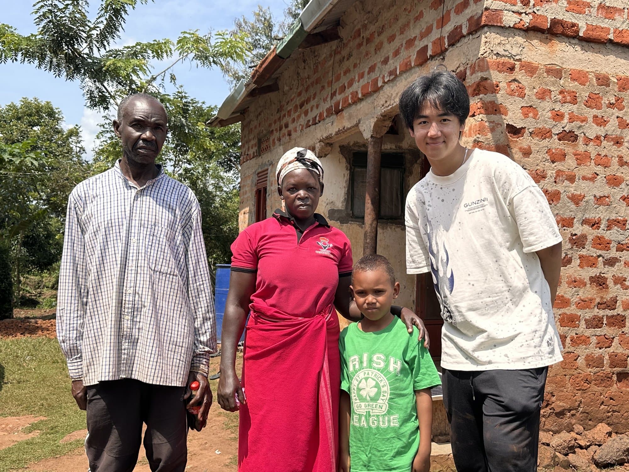 Eric Wang meeting with a family outside their home in Uganda