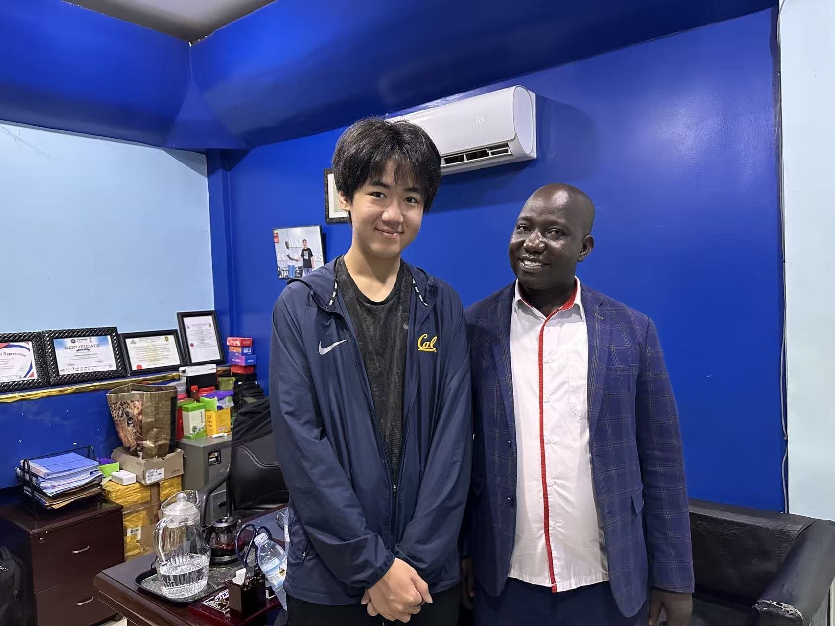 Eric Wang meeting with a local partner in an office in Uganda