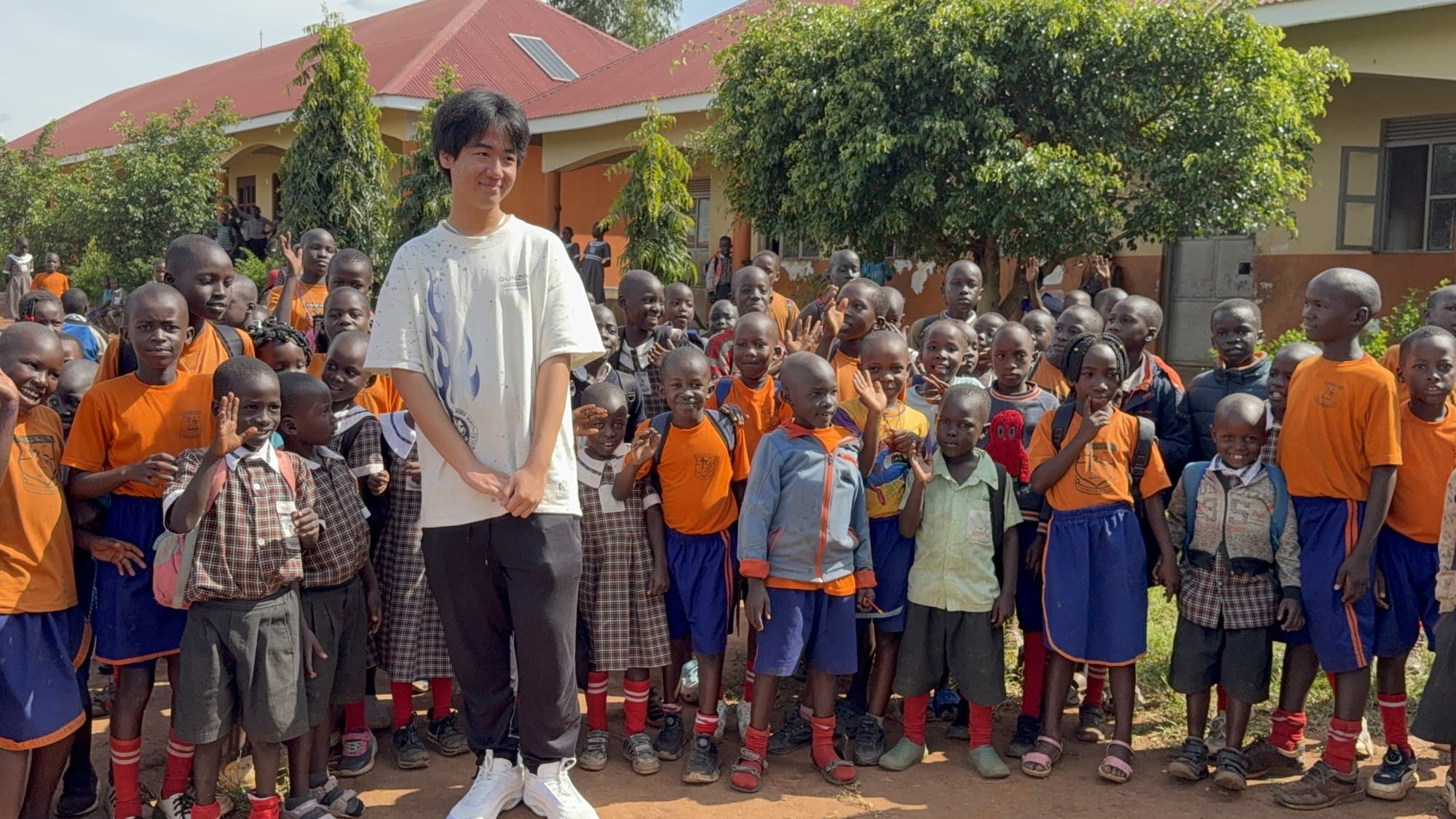 Eric Wang with a group of schoolchildren and educators in Uganda